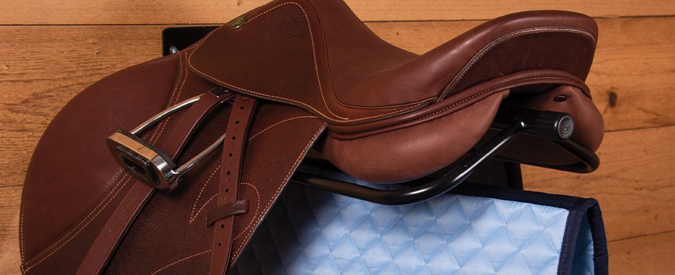 A Black Mounted Saddle Rack with a English Saddle and Pad