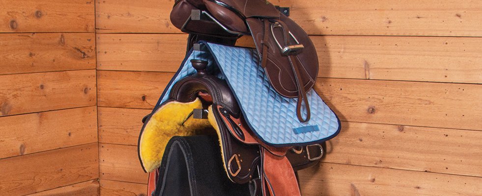 A Mounted Saddle Rack with both English and Western Saddles and Pads